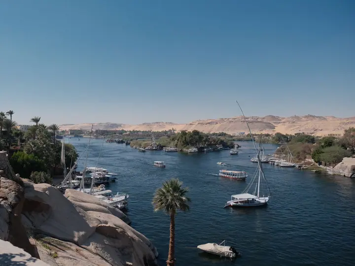 Boats, palms and rocky riverbanks in Aswan