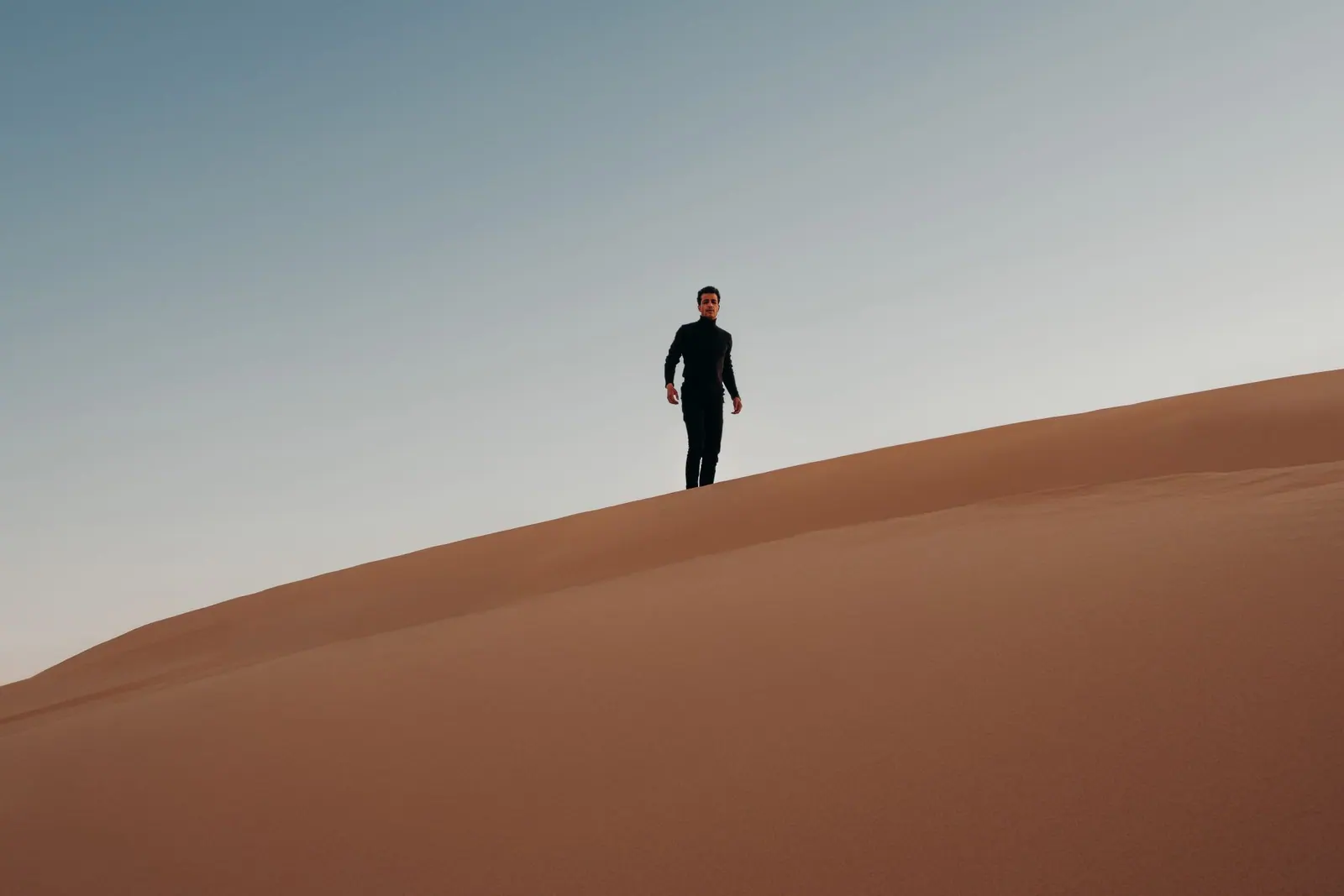 Wind-shaped dunes beneath a clear sky in Egypt