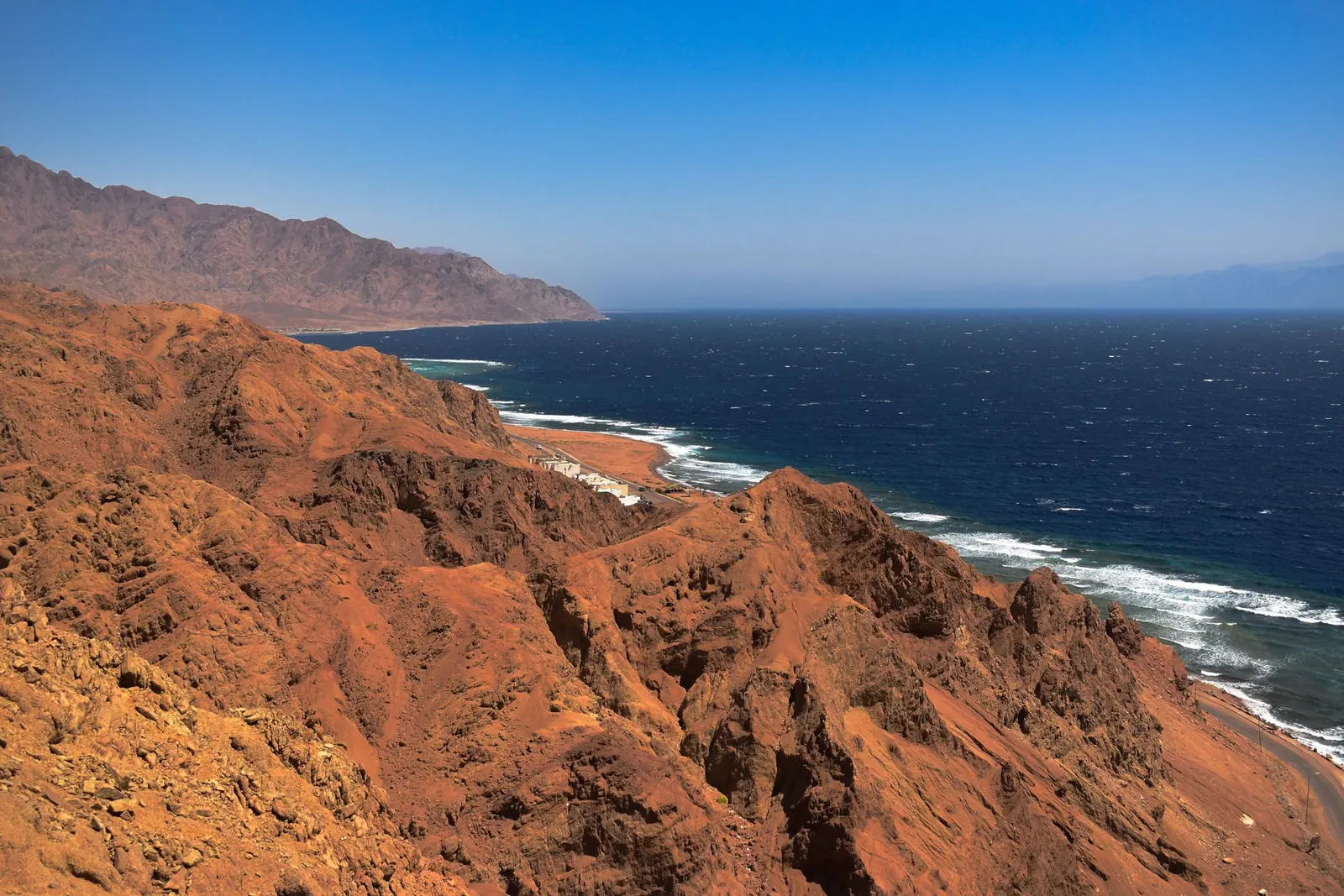 Clear blue water and dry coastal mountains in Sinai
